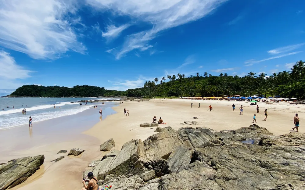 Praia de Tiririca em Itacaré com visitantes caminhando e aproveitando o visual da praia